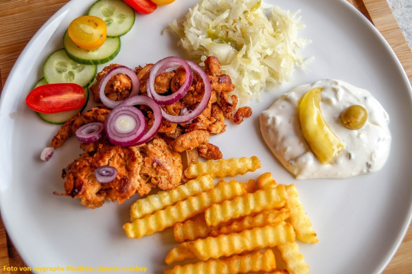 Gyros-mit-Pommes-frites-Krautsalat-und-Tzatziki-auf-einem-Teller